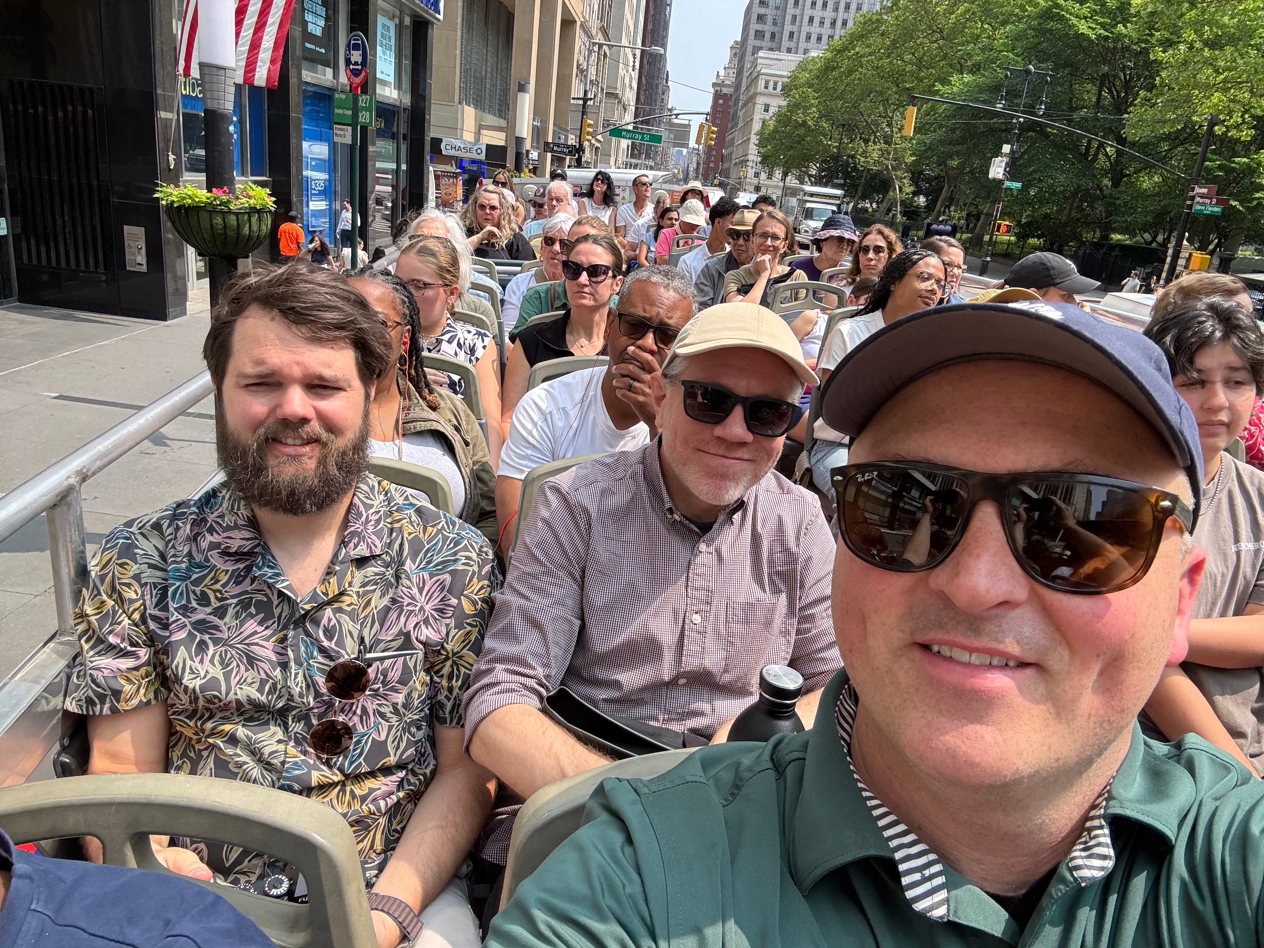 Atomic team members on the top deck of a double-decker bus touring New York City